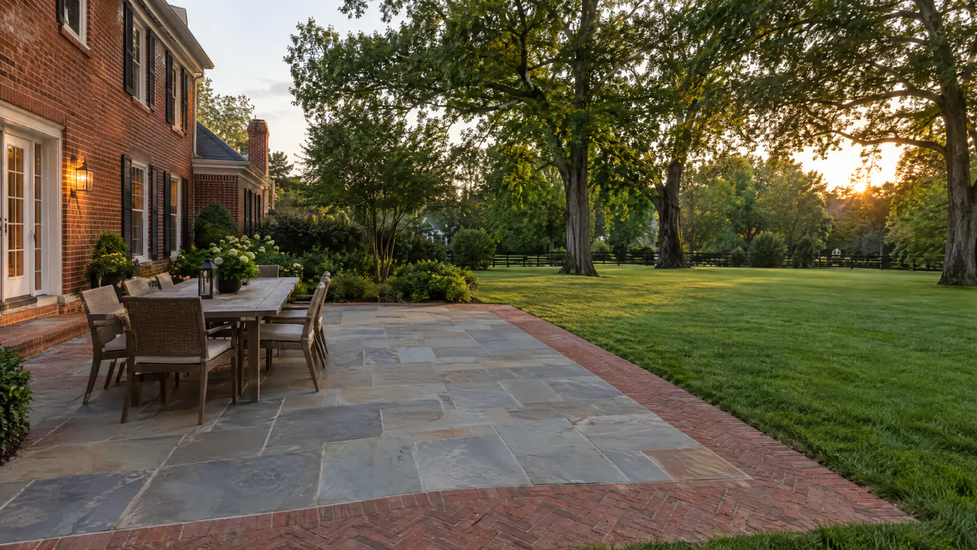 Bluestone and clay brick paver patio behind a Northern Virginia brick colonial on a summer evening
