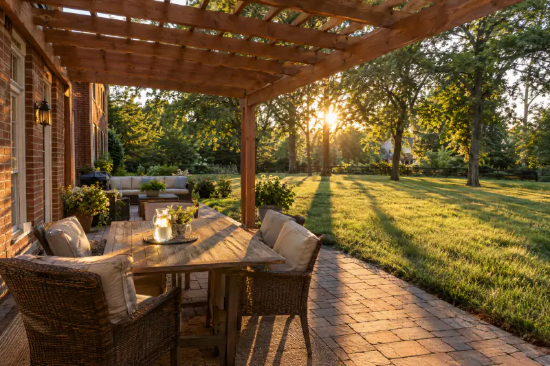 Long afternoon shadows from pergola rafters stretching across a Northern Virginia patio as the sun drops in the west