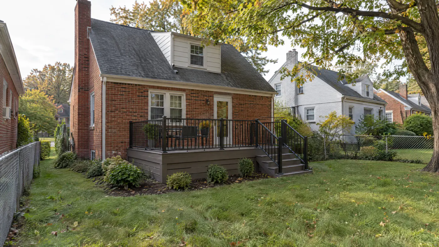 Compact composite deck on a brick Cape Cod house in a close Arlington neighborhood with neighbors a few feet away
