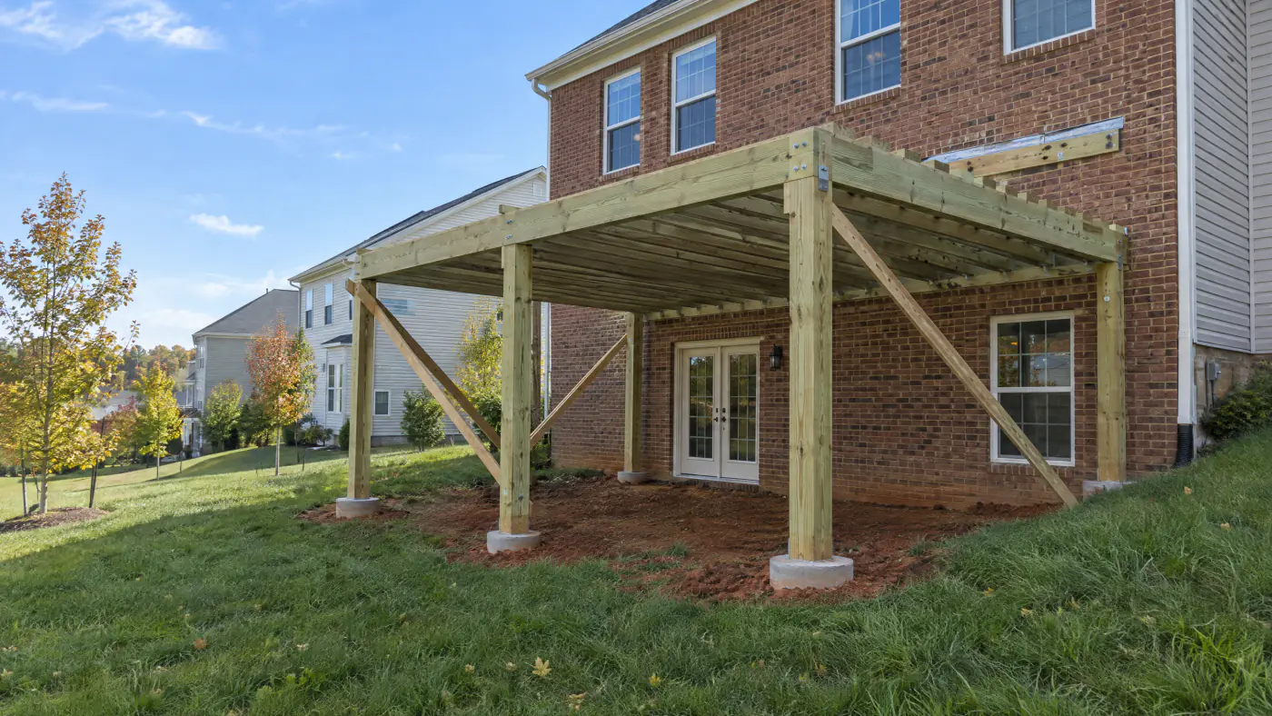 Raised deck frame on tall six by six posts behind a walkout basement colonial in a newer Prince William County subdivision