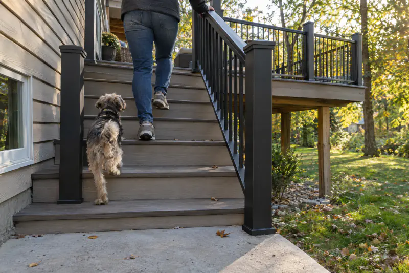 Rebuilt deck stairs with new handrail in use after deck repair
