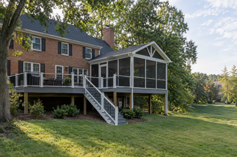 Finished backyard deck and screened porch on a brick colonial home