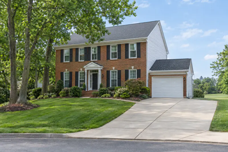 Clean driveway, siding and roof on a suburban home after exterior cleaning