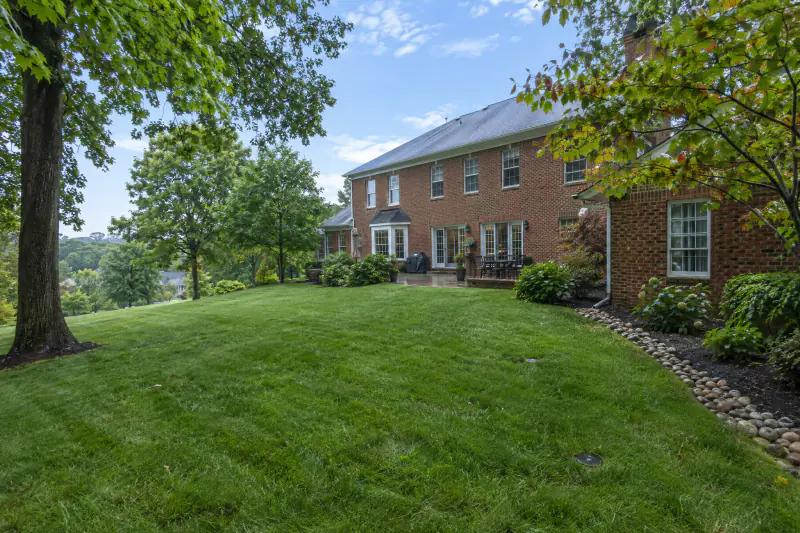 Well-drained backyard lawn at a brick colonial home showing residential water management work